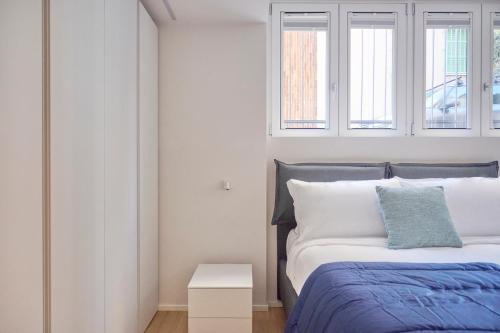 a bedroom with a bed and two windows at Milan Retreats Fiera Milano City in Milan
