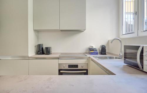 a white kitchen with a sink and a stove at Milan Retreats Fiera Milano City in Milan