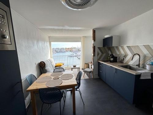 une cuisine avec une table et des chaises dans une pièce dans l'établissement Studio Cabine Gruissan, à Gruissan