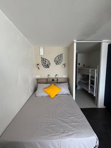 Cette petite chambre comprend un lit avec un oreiller jaune. dans l'établissement Studio Cabine Gruissan, à Gruissan