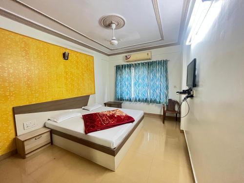a bedroom with a bed and a tv in it at Hotel Ashutosh I 300mtr from shreenathji temple I 966o9o1oo6 in Nāthdwāra