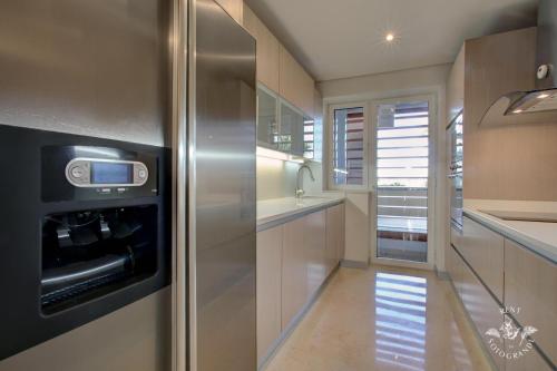 a kitchen with a refrigerator and a sink at Ribera del Marlin - Sotogrande in Sotogrande