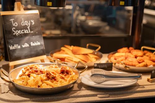 a table topped with plates of food and pies at Thavorn Palm Beach Resort Phuket in Karon Beach