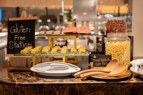 a buffet with a display of muffins and other food at Thavorn Palm Beach Resort Phuket in Karon Beach