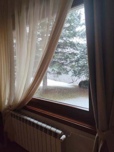 a window with a view of a tree at Ловна резиденция ДЛС Извора in Devin