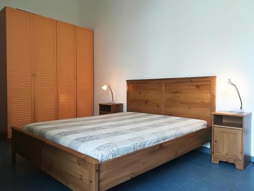 a bedroom with a wooden bed and wooden cabinets at Afr0dite'home Historic Center Otranto Seafront in Otranto