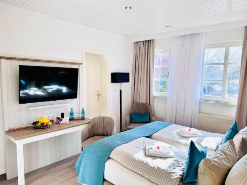 a hotel room with a bed and a flat screen tv at Inselsünn Hotel und Apartments in Spiekeroog