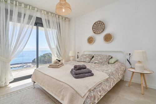 Un dormitorio con una cama y una ventana grande. en Icon Marina D, en La Herradura