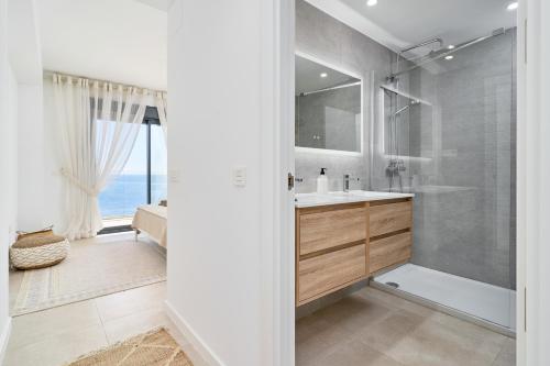 un baño con lavabo y ducha en Icon Marina D, en La Herradura
