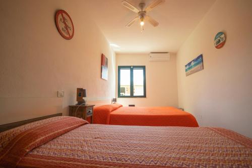 a bedroom with two beds and a ceiling fan at Il Pepe Rosa in Posada