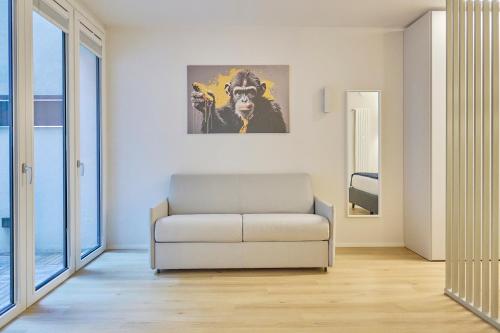 a living room with a couch and a painting on the wall at Milan Retreats Fiera Milano City in Milan