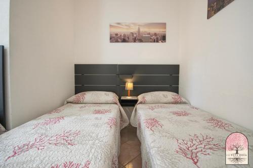 two twin beds in a room with a picture on the wall at Il Pepe Rosa in Posada
