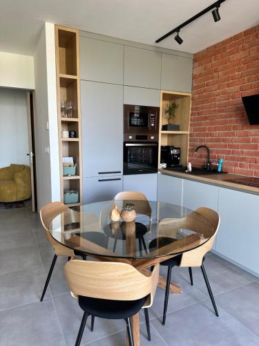 a kitchen and dining room with a glass table and chairs at Apartman Pinia in Banka