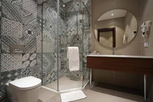 a bathroom with a shower and a toilet and a sink at CONTINENTAL DARVOZ Hotel in Dashtak