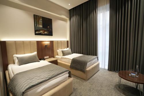 a hotel room with two beds and a table at CONTINENTAL DARVOZ Hotel in Dashtak