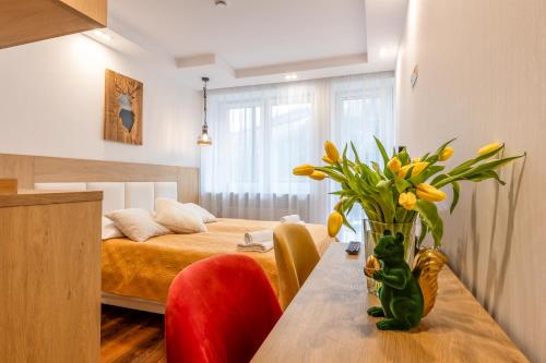 a room with a bed and a table with yellow flowers at Ryterski in Rytro
