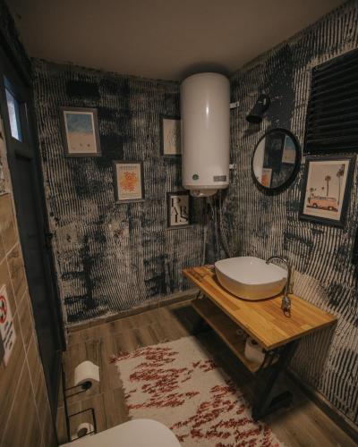 a bathroom with a toilet and a sink on a wall at Ordu Bungalov-Loin du Monde in Perşembe