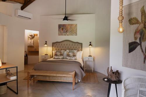 a bedroom with a large bed and a table at Sashwa River of Stars Plant-Based Wellness Safari Lodge in Hoedspruit