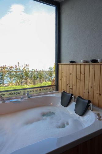 a large bath tub with a window in a bathroom at Ordu Bungalov-Loin du Monde in Perşembe