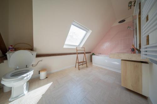 La salle de bains est pourvue de toilettes, d'une baignoire et d'une fenêtre. dans l'établissement Great Accommodation Colmar Free Parking, à Colmar