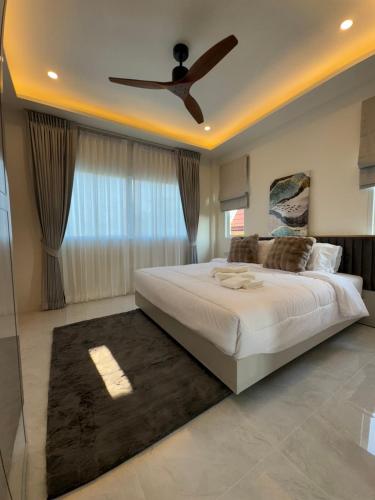 Un dormitorio con una cama grande con ventilador de techo. en Nacha Villa, en Rawai Beach