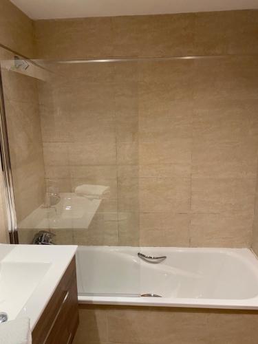 a bathroom with a white tub and a sink at Mai&Maud Fira Apartment in Hospitalet de Llobregat