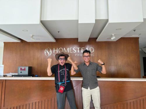 two men are standing in front of a counter at Homestead Seaview Phu Quoc Hotel in Phu Quoc