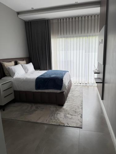a bedroom with a bed and a large window at The Views at 492 Euphoria Golf Estate in Naboomspruit