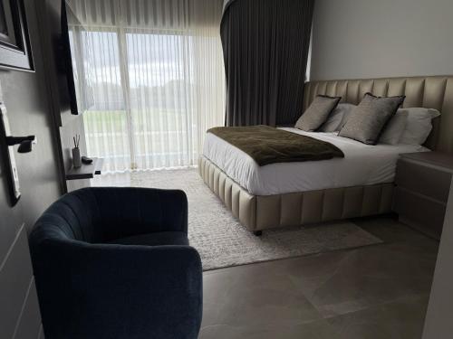 a bedroom with a bed and a chair at The Views at 492 Euphoria Golf Estate in Naboomspruit
