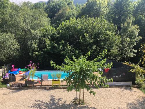 a swimming pool in a yard with trees at Au bord de l eau in Surba