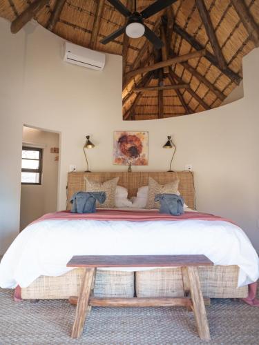 a bedroom with a large bed and a wooden ceiling at Sashwa River of Stars Plant-Based Wellness Safari Lodge in Hoedspruit
