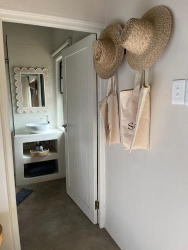 a bathroom with a white door and a mirror at Sashwa River of Stars Plant-Based Wellness Safari Lodge in Hoedspruit