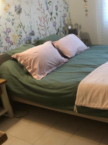 a bed with two pillows on top of it at Au bord de l eau in Surba