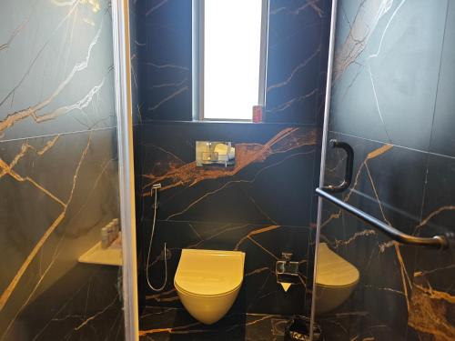a bathroom with a yellow toilet and a sink at Manas Lifestyle Resort, Igatpuri in Igatpuri