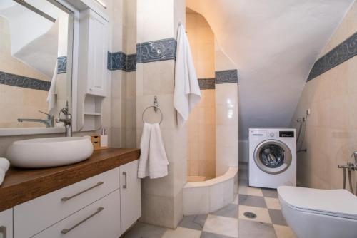 a bathroom with a sink and a washing machine at Cavos Paros Private Pool Oasis in Aliki
