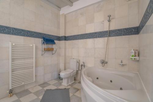 a bathroom with a white tub and a toilet at Cavos Paros Private Pool Oasis in Aliki