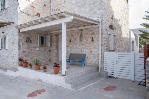 a stone house with a wooden porch with at Cavos Paros Private Pool Oasis in Aliki