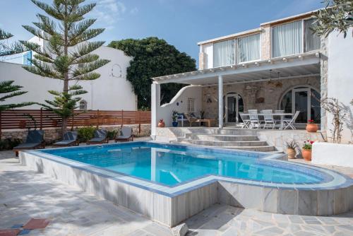 a swimming pool in front of a house at Cavos Paros Private Pool Oasis in Aliki