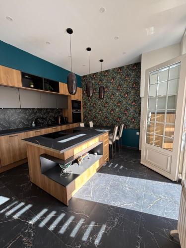 une cuisine avec une table et des chaises dans une pièce dans l'établissement Appartement élégant au cœur de Cabourg, à Cabourg