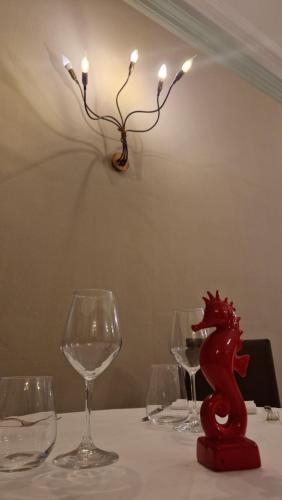 a table with wine glasses and a red dragon statue on it at Villa Cavalleri in Gattinara