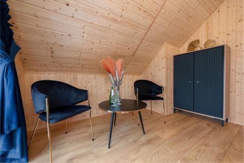 a room with a table and two chairs and a black cabinet at Złota Palma Kopań -domki całoroczne nad morzem in Kopań