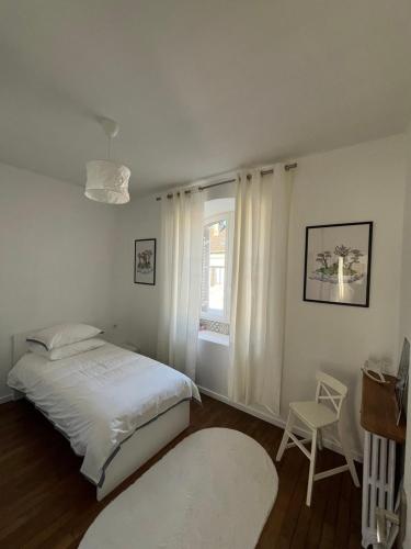 une chambre avec un lit, une chaise et une fenêtre dans l'établissement Appartement de la Diane, à Villers-Cotterêts