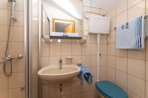 a small bathroom with a sink and a toilet at Apartman Dinko in Bol