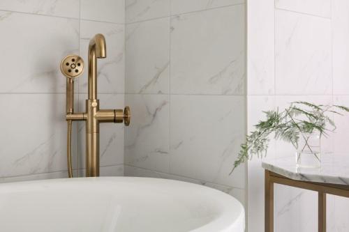 a bath tub with a gold faucet in a bathroom at InterContinental Indianapolis by IHG in Indianapolis