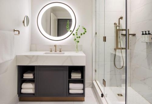 a bathroom with a sink and a shower with a mirror at InterContinental Indianapolis by IHG in Indianapolis