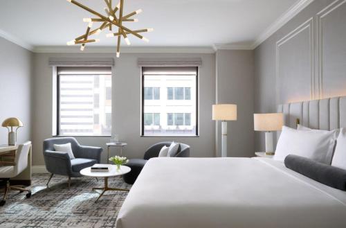 a hotel room with a bed and a desk and chairs at InterContinental Indianapolis by IHG in Indianapolis