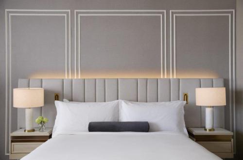 a bedroom with a large white bed with two lamps at InterContinental Indianapolis by IHG in Indianapolis