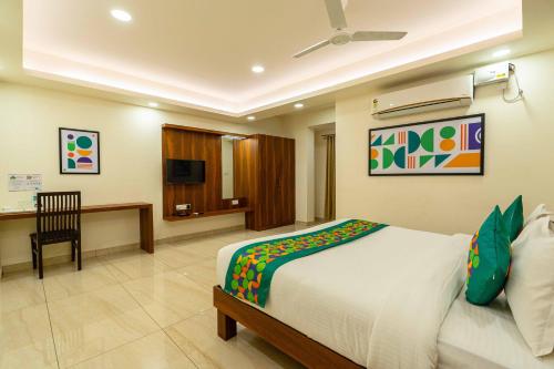a bedroom with a bed and a desk and a television at Treebo Kings Orchid in Bengaluru