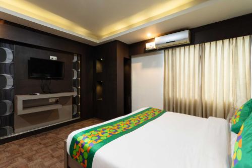 a hotel room with a bed and a television at Treebo Kings Orchid in Bengaluru
