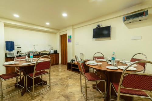 a conference room with tables and chairs and a television at Treebo Kings Orchid in Bengaluru